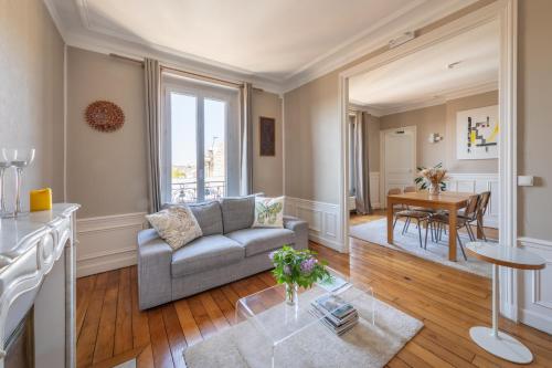 un salon avec un canapé et une table dans l'établissement Appartement calme avec cachet (20 min de Paris), à Maisons-Laffitte