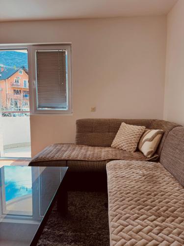 a living room with a couch and a window at Apartment Silence B in Pluzine