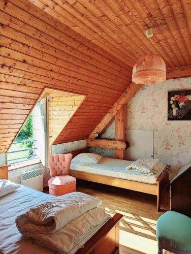 deux lits dans une chambre avec un plafond en bois dans l'établissement Charmante longère bretonne dans le Morbihan, à Brech