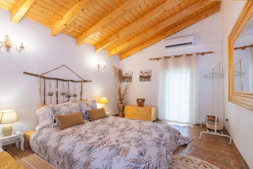 una camera da letto con un letto grande e un soffitto in legno di Quinta do Silencio a Tavira
