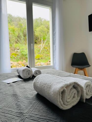 - un lit avec des serviettes et une fenêtre dans l'établissement Villa Mare è Machja avec piscine et vue mer, à Sari-Solenzara