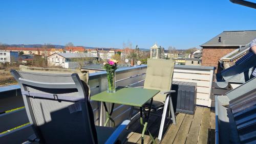 a small table on a balcony with a vase of flowers at Ferienwohnung An der Seidewitz in Pirna