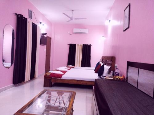 a bedroom with a bed and a table in a room at Samant Beach Resort in Malvan