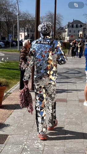 a person in a costume walking down a sidewalk at Trouville Palace Le Bonheur in Trouville-sur-Mer