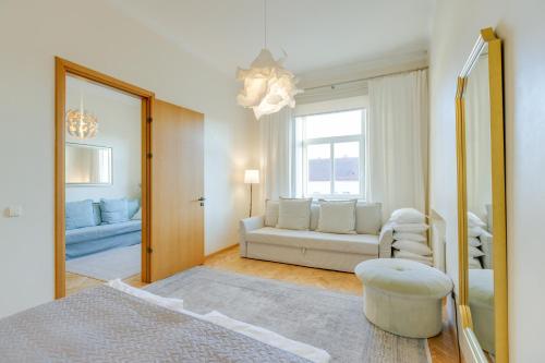 ヴィリニュスにあるTyzen39&38 Luxury Apartmentのソファと鏡のあるリビングルーム