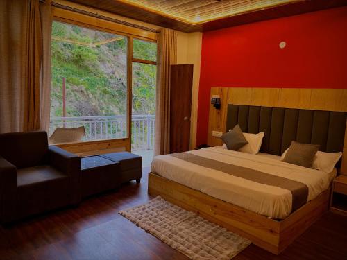a bedroom with a bed and a chair and a window at Orchard Heights, Manali in Jagatsukh