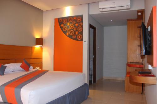 a hotel room with a bed and a television at Grand Sinar Indah in Legian