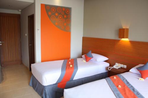 a hotel room with two beds in a room at Grand Sinar Indah in Legian