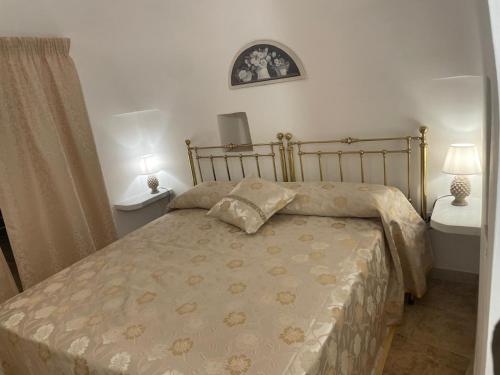 a bedroom with a bed and two tables and a window at Il Trullo L'amore di Nonna in Martina Franca