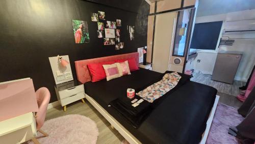 a small bedroom with a black bed and a desk at Romantic Nature Loft with Breakfast Near Underground River, Perfect Stop Between Puerto and El Nido in Puerto Princesa City