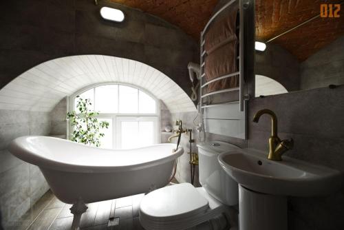 ein Badezimmer mit Badewanne, Waschbecken und Toilette in der Unterkunft Apartment Masoch Style in Lwiw