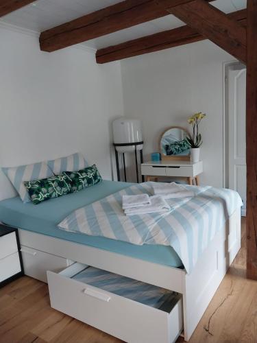 a bedroom with a bed with blue and white sheets at schickes gemütliches Studio in Bühler