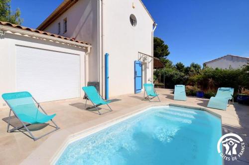 une piscine avec des chaises et une maison dans l'établissement vent du cap, à La Ciotat