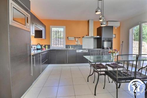 une cuisine avec une table en verre et des chaises. dans l'établissement vent du cap, à La Ciotat