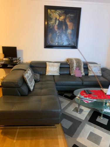 a living room with a brown leather couch at KARIBU chic in Bezons