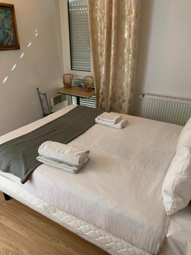 - un lit avec 2 serviettes assises au-dessus dans l'établissement KARIBU chic, à Bezons