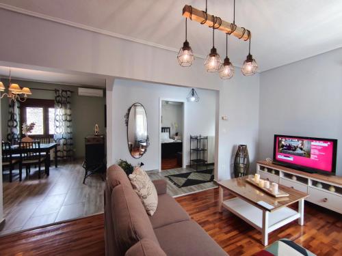 Una sala de estar con un sofá y un televisor. en Heliopetra, en Kalambaka