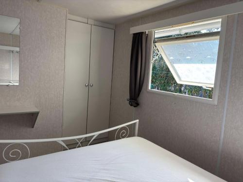 une chambre avec un lit et une fenêtre dans l'établissement Mobil-home sud ardeche 6 personnes avec clim, à Orgnac-lʼAven