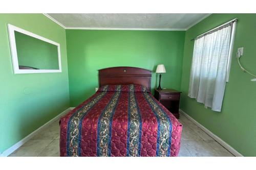 a bedroom with a bed and green walls at Monterrey Motel Padre Island, Corpus Christi BY OYO in Corpus Christi