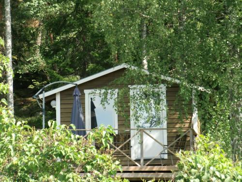 a cabin in the woods with an umbrella at Vandrarhemmet Tallbacka/Ängelsberg Hostel in Ängelsberg