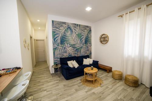 un salon avec un canapé bleu et une table dans l'établissement Holiday House ViscaUno, à Nettuno