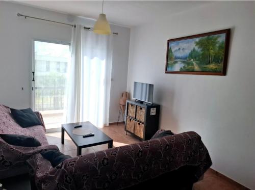 a living room with a couch and a table at Sunset Green 02 in Paphos City