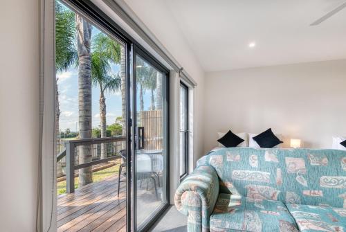 a living room with a couch and a sliding glass door at Inverloch Motel in Inverloch