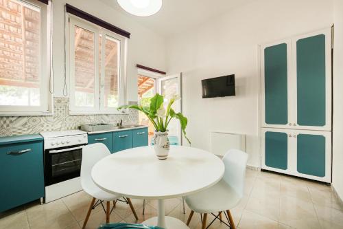 a kitchen with blue cabinets and a white table and chairs at Ciraccio Apartments in Procida