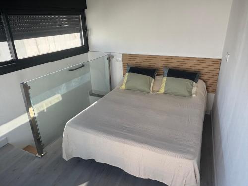 a small bedroom with a bed and a window at Conil Playa 200 metros Casa barrio de los pescadores in Conil de la Frontera