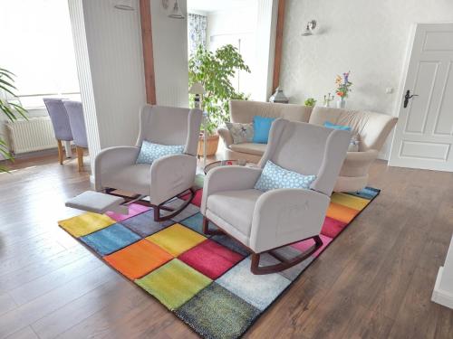 a living room with two chairs and a rug at Komfortfewo Meeresleuchten in Sassnitz