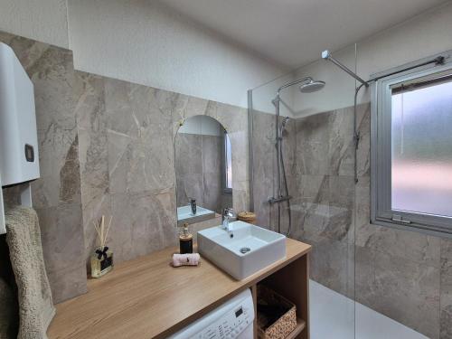 une salle de bain avec un lavabo et une douche dans l'établissement T2 vue mer, proche plage & parking privée, à Bandol