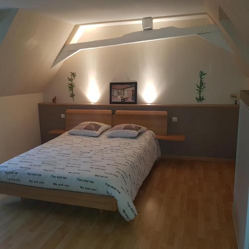 une chambre avec un lit avec deux oreillers dessus dans l'établissement appartement avec une chambre avec un grand lit , une d'enfant et un clic-clac dans la piece de vie, à Bazouges-sur-le-Loir