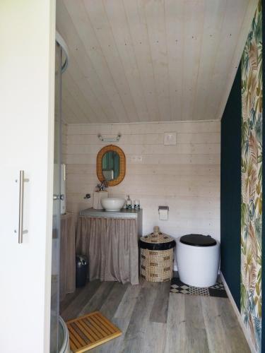 une salle de bain avec une baignoire et un lavabo dans l'établissement Chalet avec SPA en pleine nature 30 min des plages lac, océan et bassin d'Arcachon, à Sainte-Hélène