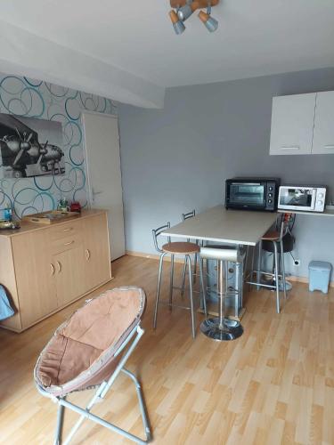 une cuisine avec une table et une chaise dans une pièce dans l'établissement appartement avec une chambre avec un grand lit , une d'enfant et un clic-clac dans la piece de vie, à Bazouges-sur-le-Loir
