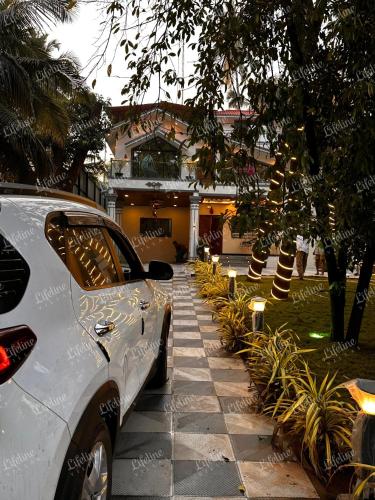 a car parked in front of a house at SEAs THE DAY LUXURIOUS 5BHK VILLA 2min From Awas Beach With Huge Private Pool in Alibaug