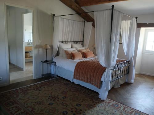 une chambre avec un grand lit à baldaquin dans l'établissement Jas des gros bonnets, à Redortiers