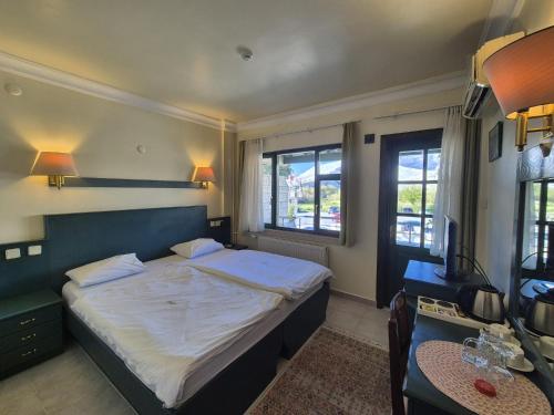 a bedroom with a bed and a desk and a television at Hotel HAL-TUR in Pamukkale