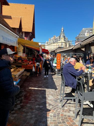 a group of people sitting at tables in a market at Trouville Palace Le Bonheur in Trouville-sur-Mer
