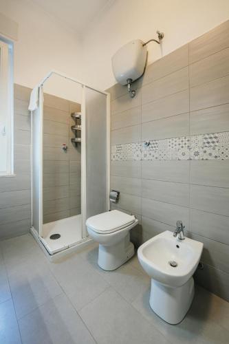a bathroom with a toilet and a shower and a sink at Ciraccio Apartments in Procida
