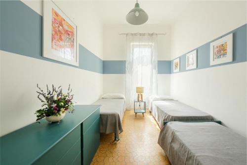 a room with two beds and a table with flowers at Ciraccio Apartments in Procida