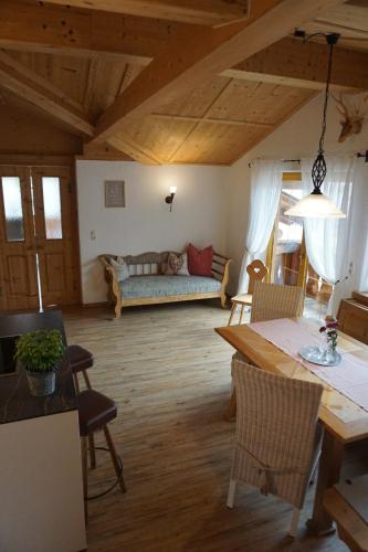 a living room with a table and a couch at Ferienwohnungen Bauernhof Andreas Kleiner in Tannheim