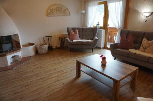 a living room with two couches and a coffee table at Ferienwohnungen Bauernhof Andreas Kleiner in Tannheim