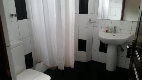 a bathroom with a white shower curtain and a sink at vino villa in Kandy