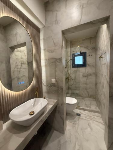 a bathroom with a sink and a toilet and a television at Aqua Mare Luxury Apartments in Paralia Katerinis
