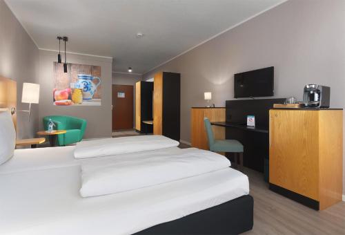 een hotelkamer met een groot bed en een bureau bij Trip Inn Hotel Egelsbach Frankfurt in Egelsbach
