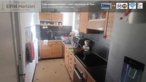 une cuisine avec des armoires en bois et des murs en carrelage noir dans l'établissement Eiffel Horizon - Grand espace familial au pied du métro, à Paris
