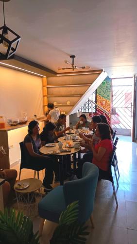 a group of people sitting at a table in a restaurant at Mandala Lux Hotel in Pisco