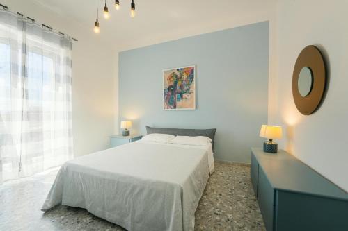 a white bedroom with a bed and a mirror at Ciraccio Apartments in Procida