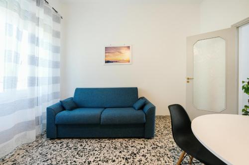 a blue couch in a room with a table at Ciraccio Apartments in Procida