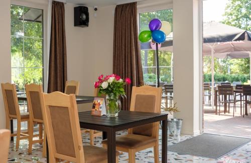 un comedor con una mesa con flores y globos en Karkle Beach Apartments, en Karklė